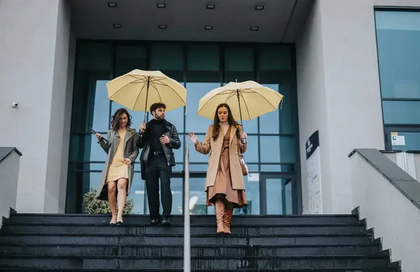 Tres Profesionales Negocios Con Paraguas Amarillo Bajando Escalones Oficina — Foto de Stock