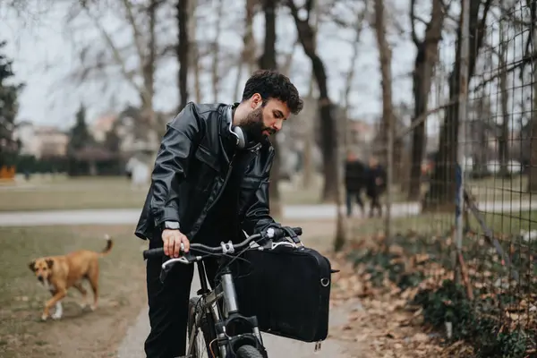 Şehir Parkında Bisiklet Sürerken Dizüstü Bilgisayar Kullanan Siyah Deri Ceketli — Stok fotoğraf