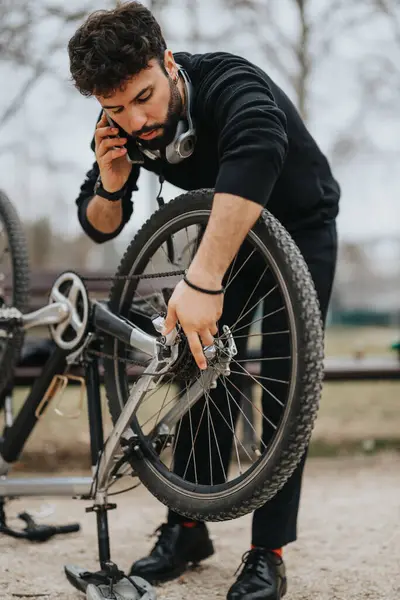 Bir Bisikleti Tamir Ederek Dışarıda Telefonla Konuşarak Birden Fazla Yapan — Stok fotoğraf
