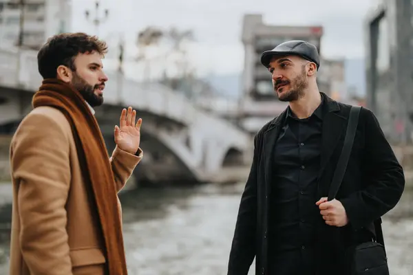 时尚的男性朋友们在一座城市的河上的桥旁聊天 描绘着休闲的城市生活方式和友谊 — 图库照片