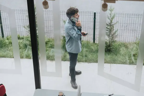 Hombre Hablando Por Teléfono Por Ventana Oficina Negocios Casuales Vista — Foto de Stock
