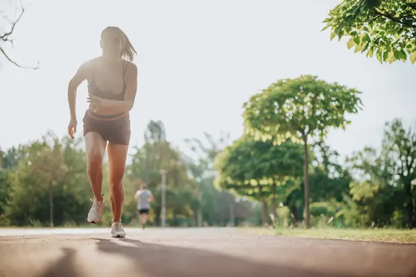 一个人在绿地公园里做运动 用他们的健康和健康的生活方式激励别人 她在户外跑步和慢跑时树立了目标 表现出了极大的力量和毅力 — 图库照片