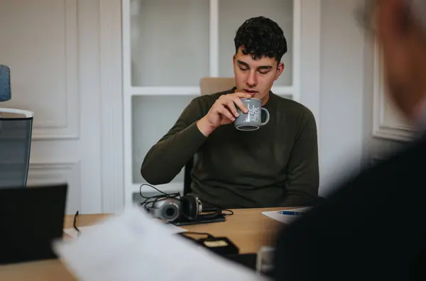 Genç Bir Adam Molasında Kahvesini Yudumluyor Yoğun Bir Ofis Ortamında — Stok fotoğraf