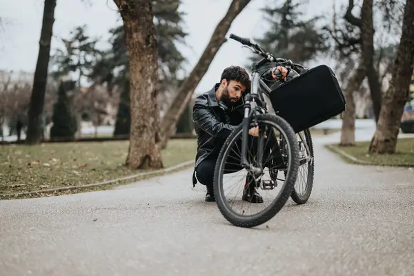 Odaklanmış Bir Erkek Girişimci Açık Hava Ortamında Bisiklet Tekerleğiyle Ilgileniyor — Stok fotoğraf