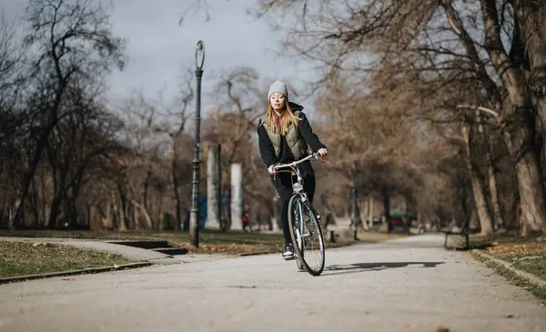 Женщина Зимней Шляпе Куртке Велосипедах Пустой Дорожке Парке Окруженной Голыми — стоковое фото