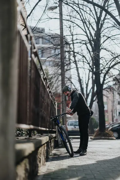 Bir Adam Güneşli Bir Şehir Kaldırımında Park Halindeki Bisikletinin Yanında — Stok fotoğraf