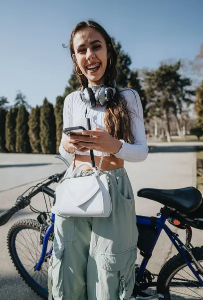 Joyeux Jeune Femme Avec Écouteurs Téléphone Intelligent Debout Côté Vélo — Photo
