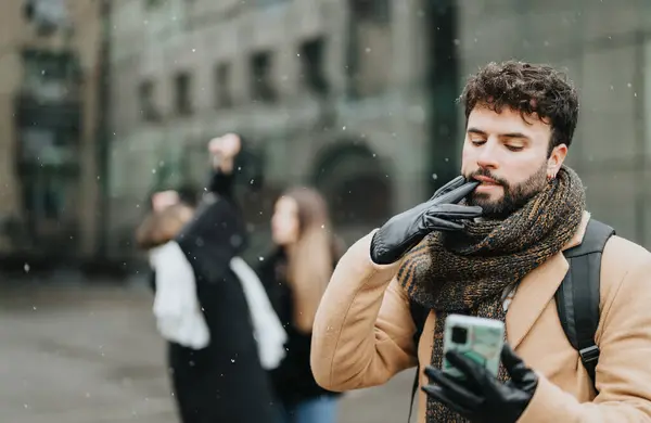 A businessman engage with smart devices in a snowy urban setting, showcasing winter weather and technology use.