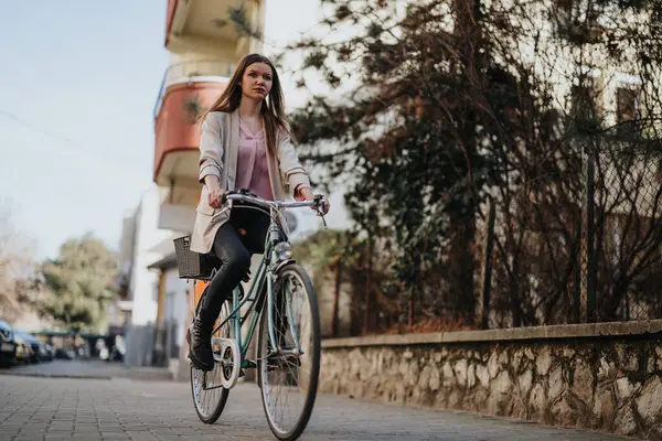 年轻的女骑手在安静的街道上自信地骑车 体现了积极的生活方式和日常的健康 — 图库照片