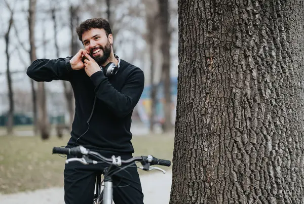 Hombre Barbudo Alegre Disfruta Una Conversación Teléfono Inteligente Apoyado Árbol —  Fotos de Stock