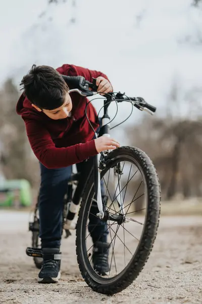 在公园里 一个男孩在被大自然包围的悠闲的骑自行车过程中专心致志地骑在自行车上 体现了自由和欢乐 — 图库照片