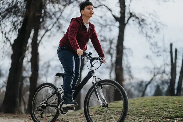 无忧无虑的小男孩骑着自行车穿过城市公园的绿地 体现了自由和欢乐 — 图库照片
