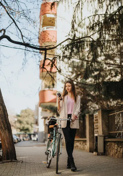 Joven Mujer Moderna Revisando Teléfono Junto Bicicleta Día Brillante Entorno — Foto de Stock