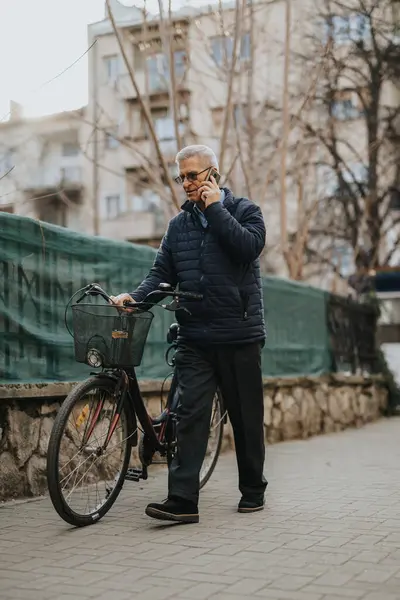 Starszy Pan Stoi Miejskim Chodniku Rozmawiając Przez Telefon Rowerem Boku — Zdjęcie stockowe