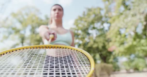 一名身穿运动服 拿着网球拍的坚定女子 准备在一个阳光灿烂的室外公园玩耍 — 图库视频影像