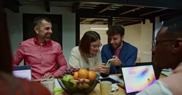多民族の同僚は 明るいオフィスで夜のワークセッション中にアイデアを共有し 仕事への共同で革新的なアプローチを強調しています — ストック動画