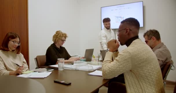 近代的なオフィス環境でのビジネスミーティング中に成長分析に焦点を当てたクリエイティブな人々の多様なグループ — ストック動画