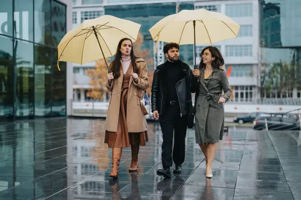 Κομψοί Φίλοι Περπατούν Κίτρινες Ομπρέλες Μια Βροχερή Πόλη — Φωτογραφία Αρχείου
