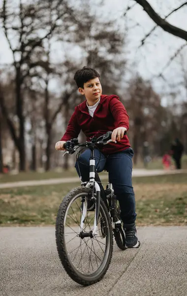 Młody Chłopiec Jeździ Rowerze Przez Park Miejski Świadcząc Zdrowym Aktywnym — Zdjęcie stockowe