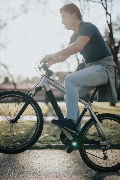 Young Adult Male Casually Riding Bicycle Bathed Sunlight Serene Park — Stock Photo, Image