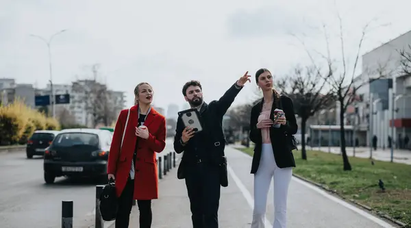Τρεις Επαγγελματίες Επιχειρηματίες Περπατούν Και Μιλούν Εξωτερικούς Χώρους Ένας Δείχνει — Φωτογραφία Αρχείου