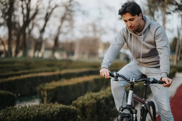 公園の静けさの中で一瞬の反射を一時停止する自転車で集中した男 — ストック写真