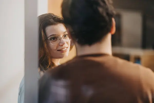 メガネをかけた笑顔の女性としての候補的な瞬間は 鏡の反射 男性を見て 親密さとつながりを呼び起こします — ストック写真