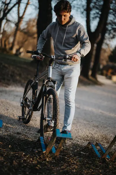 若い男は穏やかな公園の設定で自転車に乗ってカジュアルな一日を楽しんで 健康でアクティブなライフスタイルを例示しています — ストック写真