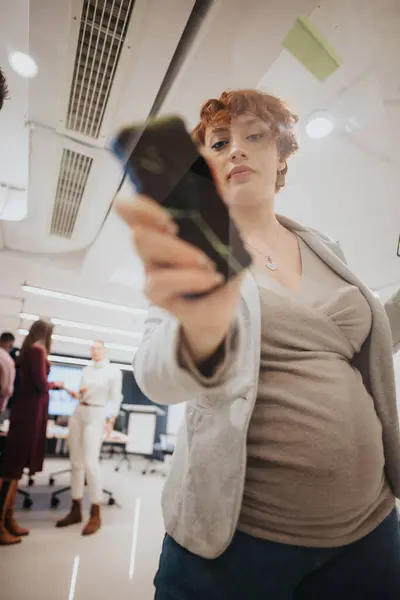 怀孕的女商人在现代办公室的玻璃墙上计划项目细节或写新的战略或统计数字 — 图库照片