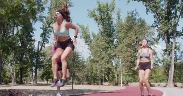 Tři Atletické Dívky Společně Cvičí Venku Skákají Ohřívají Cvičení Demonstrují — Stock video