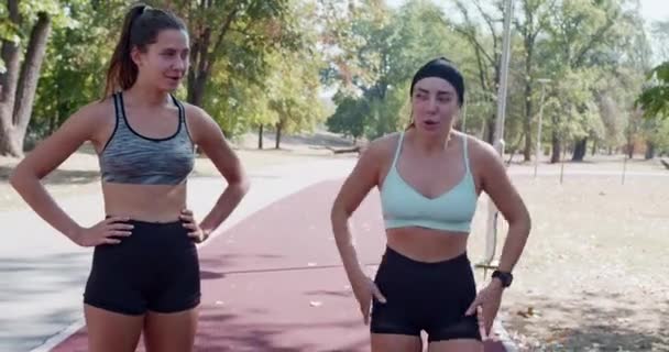 Actieve Jonge Vrouwen Rusten Lachen Het Joggen Een Zonnig Park — Stockvideo