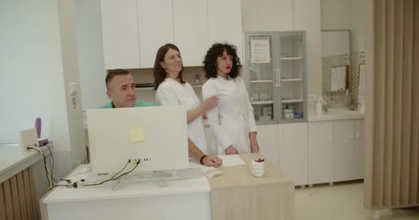 相貌堂堂的医生和漂亮的护士在现代医生办公室拍照 — 图库视频影像