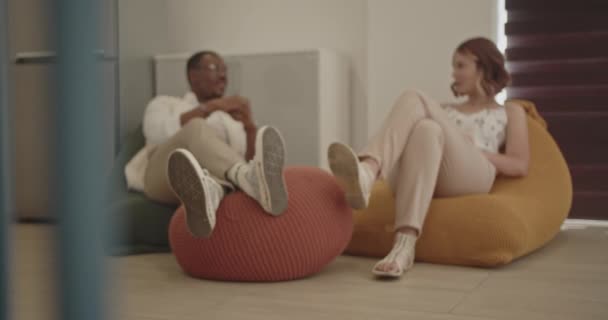 사무실 라운지 공간에서 작업에서 휴식을 취하는 코카서스 여성과 남성의 초점보기 — 비디오