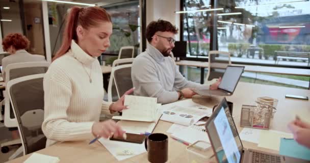 焦点を当てたビジネス同僚は 最新のオフィス環境で新しいプロジェクトとブレインストーミングソリューションに協力し チームワークと革新的な思考を紹介しています — ストック動画