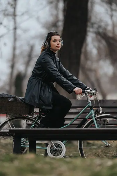 スタイリッシュで自信に満ちた若いビジネスマンが静かな都会の公園で彼女のヴィンテージ自転車に乗る — ストック写真