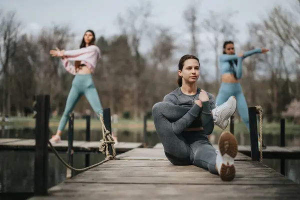 Tres Atletas Femeninas Realizan Ejercicios Estiramiento Promoviendo Aptitud Salud Lugar — Foto de Stock