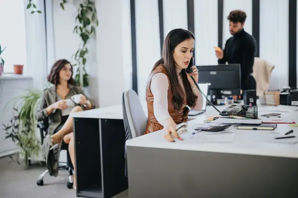 Geschäftiges Büro Mit Einer Fokussierten Frau Telefon Einem Entspannten Kollegen — Stockfoto