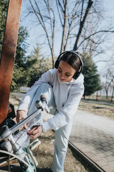 Young Woman Wearing White Hoodie Sweatpants Locks Her Bike Sunny — Stock Photo, Image