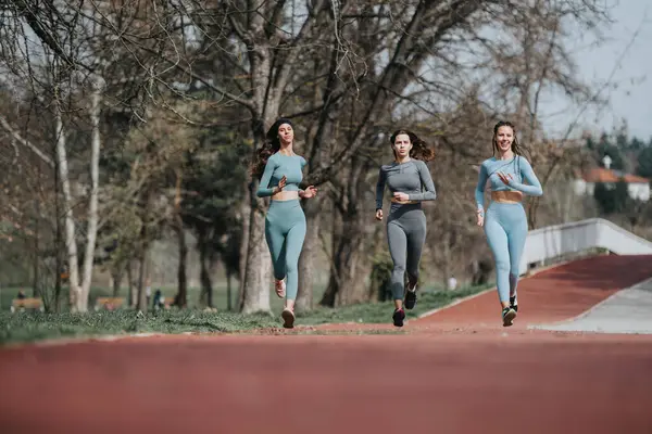 stock image Active women in sportswear running outdoors, embodying a healthy lifestyle and determination.