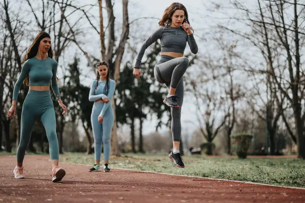 Drie Atletische Vrouwen Bijpassende Workout Gear Doen Oefeningen Een Baan — Stockfoto