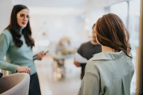 Two Women Engaging Discussion Male Colleague Blurred Background Bright Contemporary — Stock Photo, Image