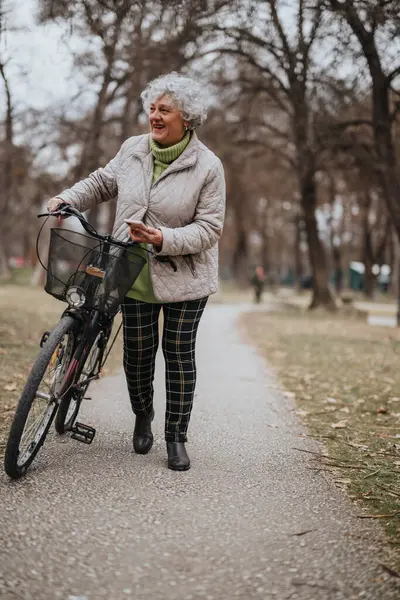 Healthy and active lifestyle concept of a mature woman with her bike in a park.
