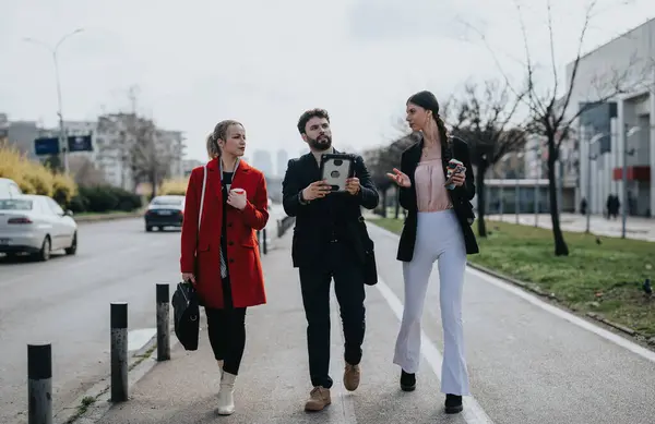 Três Profissionais Elegantes Caminham Juntos Dia Brilhante Envolvidos Uma Conversa — Fotografia de Stock