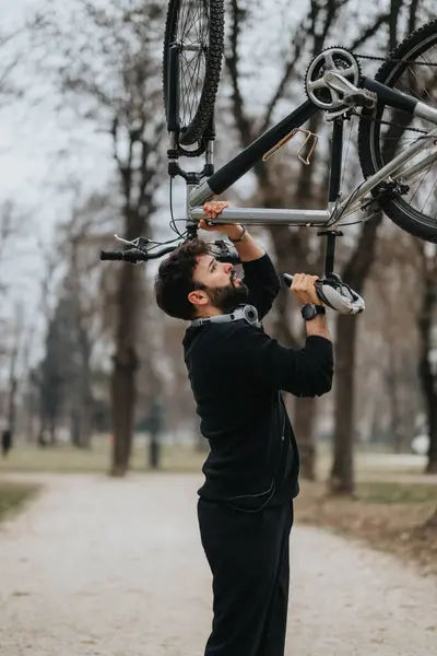 若いプロの起業家は 穏やかな公園の設定で自転車を運ぶことによって仕事から休憩を取ります — ストック写真