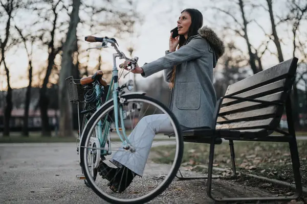 Элегантная Деловая Женщина Велосипеде Отвечает Телефонный Звонок Скамейке Парке Вечером — стоковое фото