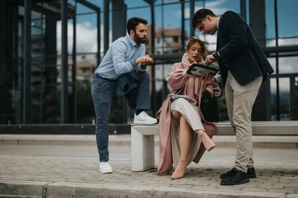 現代のオフィスビルの外で深刻な議論を行い チームワークとコラボレーションを表示するカジュアルな衣装の3人のプロのビジネス同僚 — ストック写真