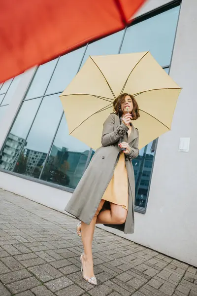 Stylová Dáma Elegantním Plášti Těší Nápoji Pod Pulzujícím Žlutým Deštníkem — Stock fotografie