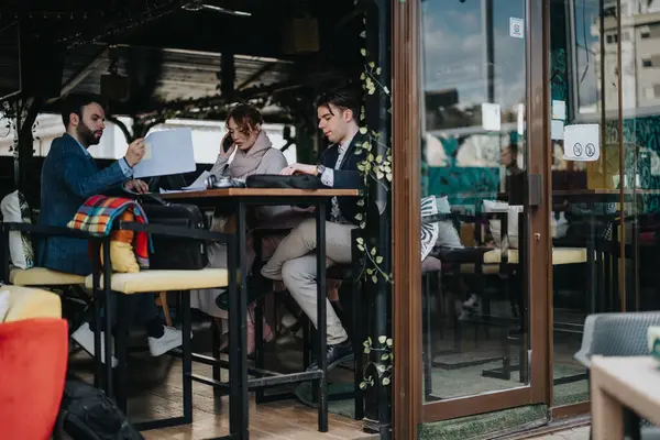 近代的な喫茶店で生産的なビジネスミーティングに従事する若い起業家 会社の成長戦略を議論 — ストック写真