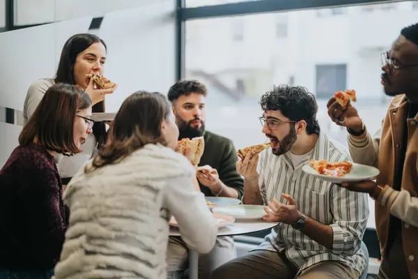 stock image Multiracial business team taking a refreshing break and enjoying pizza together.