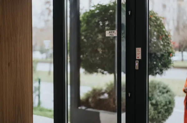 引き印が付いている現代ガラス ドアを通して眺め 明るい日に電子アクセス制御パネルが装備されている — ストック写真
